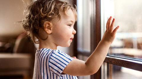 Child waving through glass image