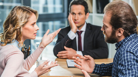 A divorcing couple arguing during mediation at a boardroom table feature photo