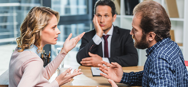A divorcing couple arguing during mediation at a boardroom table feature photo