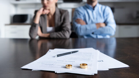 Disgruntled couple in front of papers and wedding rings