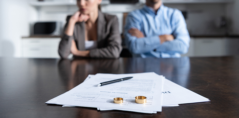 Disgruntled couple in front of papers and wedding rings